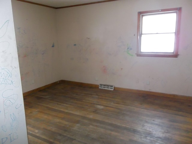 spare room featuring visible vents, baseboards, wood finished floors, and ornamental molding