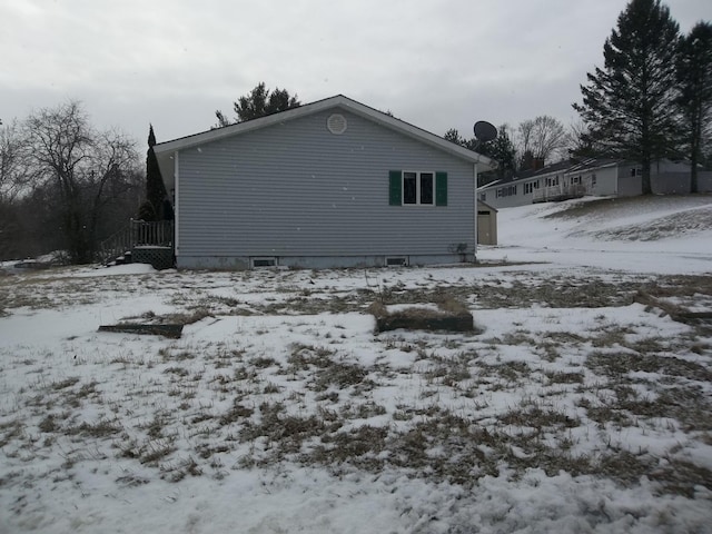 view of snowy exterior with crawl space