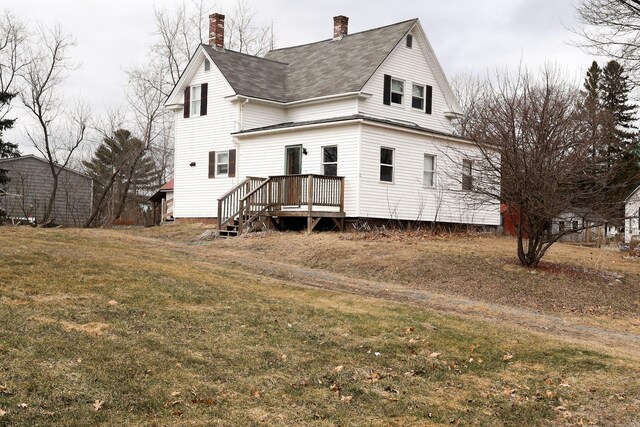 12 Pleasant St, Howland, ME 04448 - back of property with a chimney, a wooden deck, a shingled roof, and a lawn