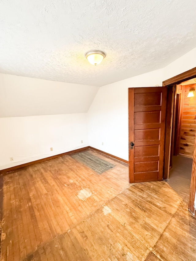 12 Pleasant St, Howland, ME 04448 - bonus room with lofted ceiling, hardwood / wood-style flooring, a textured ceiling, and baseboards