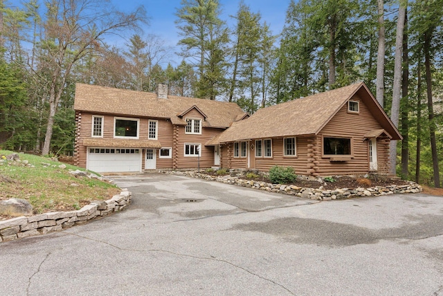 52 Main St, Sanford, ME 04083 - view of front of property featuring an attached garage, log exterior, a chimney, and driveway