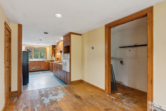 52 Main St, Sanford, ME 04083 - kitchen with brown cabinets, light wood finished floors, light countertops, recessed lighting, and white oven