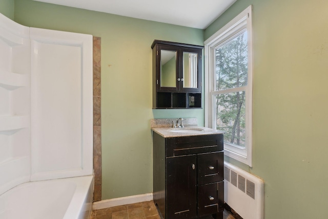 52 Main St, Sanford, ME 04083 - bathroom with radiator heating unit, vanity, baseboards, and a wealth of natural light