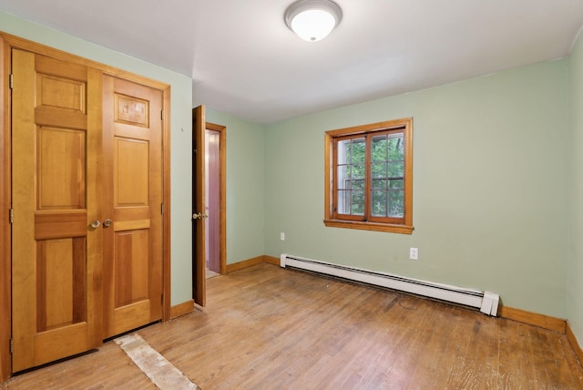 52 Main St, Sanford, ME 04083 - unfurnished bedroom featuring baseboards, a baseboard heating unit, and light wood-style floors