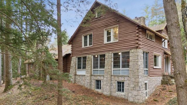 52 Main St, Sanford, ME 04083 - view of home's exterior with log siding, a chimney, and stone siding