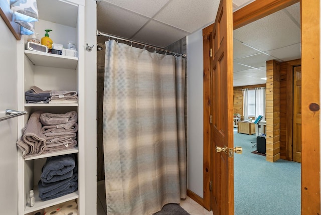 full bath featuring curtained shower, a paneled ceiling, and wood walls