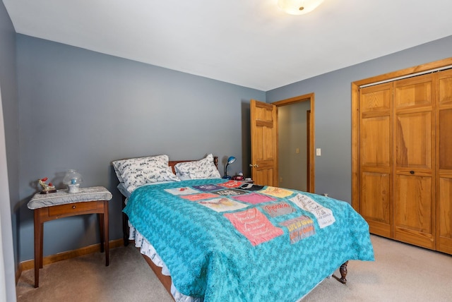 bedroom with a closet, baseboards, and light colored carpet