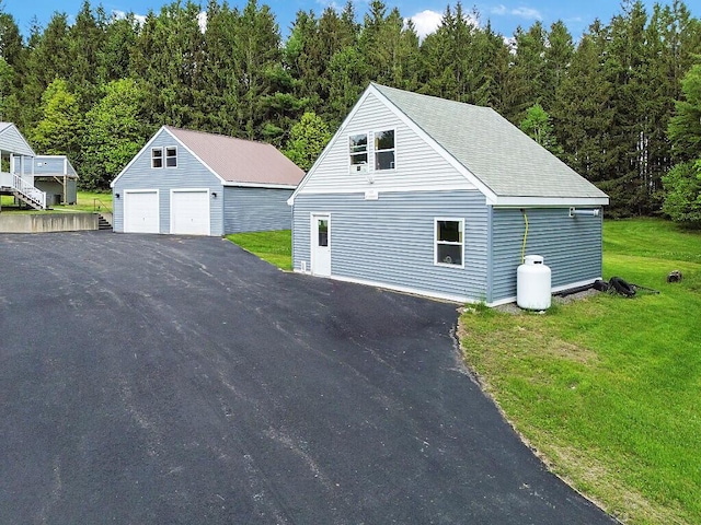 20 Pit Rd, Windsor, ME 04363 - view of front facade with a detached garage, an outdoor structure, a front lawn, and a wooded view