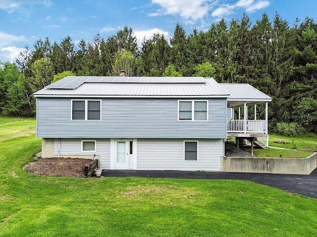 20 Pit Rd, Windsor, ME 04363 - rear view of property with a lawn, metal roof, solar panels, and covered porch