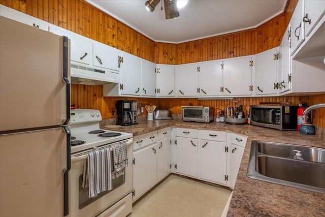 kitchen featuring white appliances, white cabinets, under cabinet range hood, and a sink