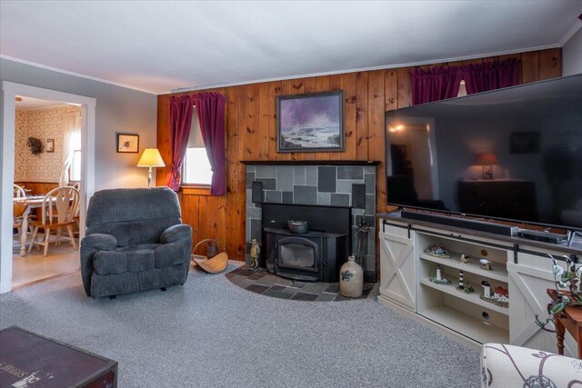 carpeted living room with a wood stove and ornamental molding