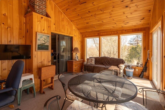 carpeted living room with lofted ceiling, wooden walls, and wood ceiling