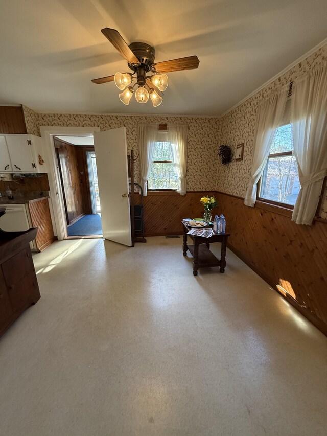 22 Sand Hill Rd, Wiscasset, ME 04578 - dining space with wallpapered walls, a wainscoted wall, a ceiling fan, and wood walls