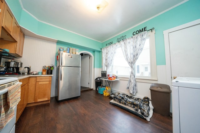 kitchen with a wainscoted wall, washer / clothes dryer, freestanding refrigerator, dark wood-type flooring, and white stove