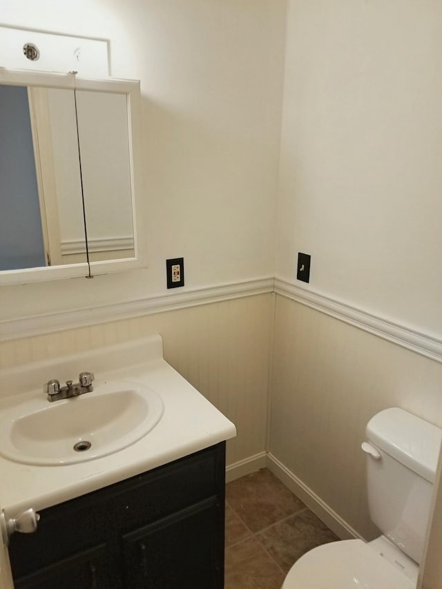 bathroom with wainscoting, tile patterned flooring, toilet, and vanity