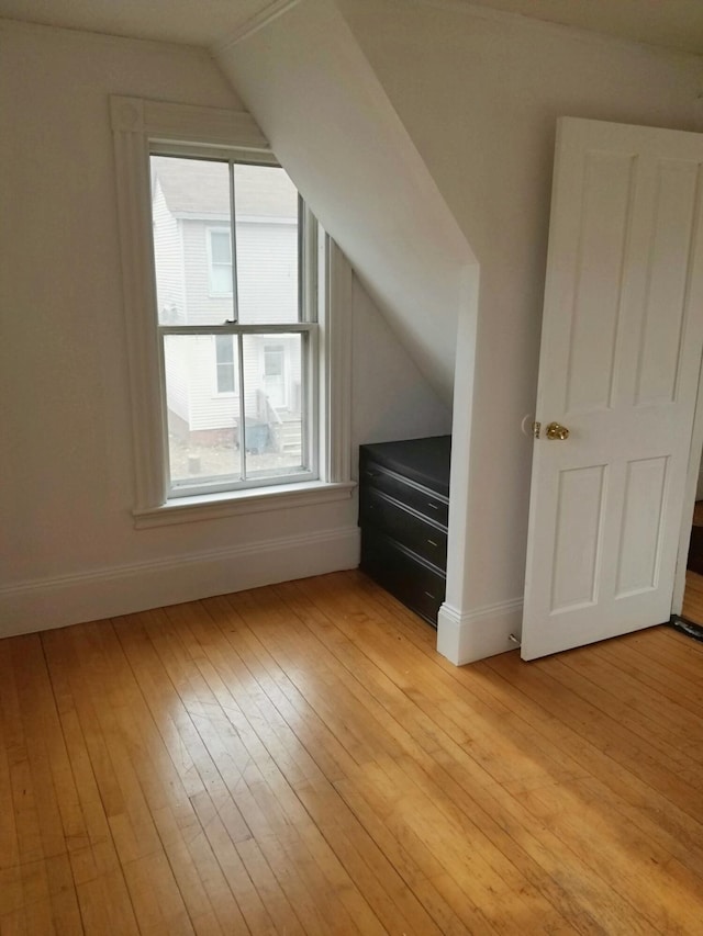 bonus room with light wood finished floors, baseboards, and lofted ceiling