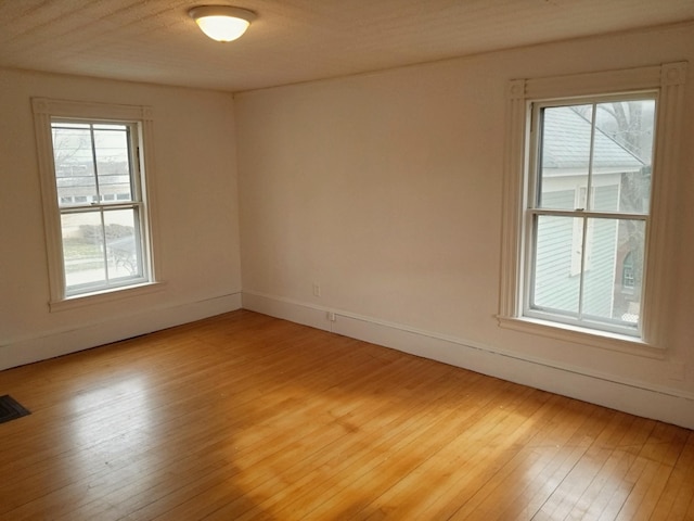 unfurnished room featuring baseboards and light wood finished floors