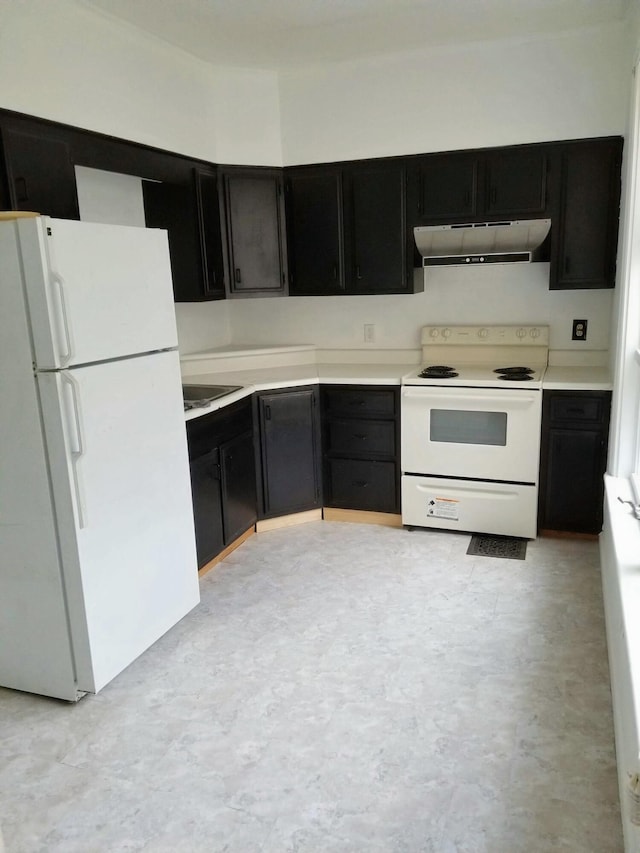 kitchen featuring under cabinet range hood, white appliances, dark cabinetry, and light countertops