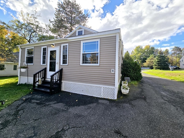 manufactured / mobile home with entry steps and a front yard