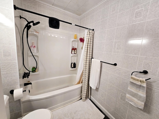 full bath with tile walls, crown molding, toilet, and shower / tub combo with curtain