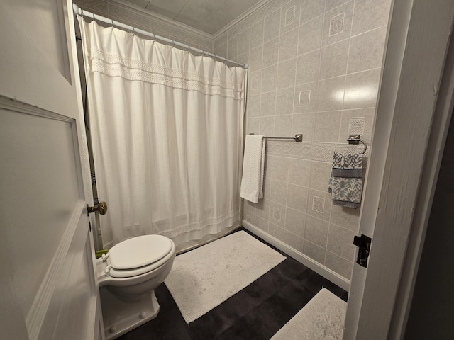 bathroom with curtained shower, toilet, tile walls, and ornamental molding