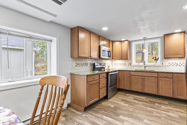8 Royal Coachman Way, Shapleigh, ME 04076 - kitchen with appliances with stainless steel finishes, a sink, light wood-style flooring, backsplash, and light stone countertops