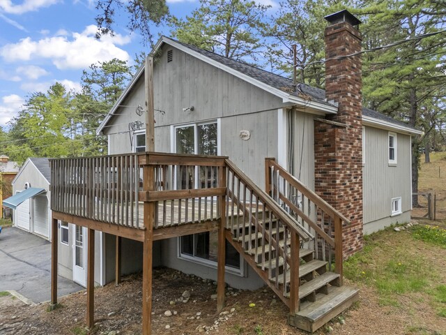 8 Royal Coachman Way, Shapleigh, ME 04076 - back of property with a garage, a chimney, a deck, and roof with shingles