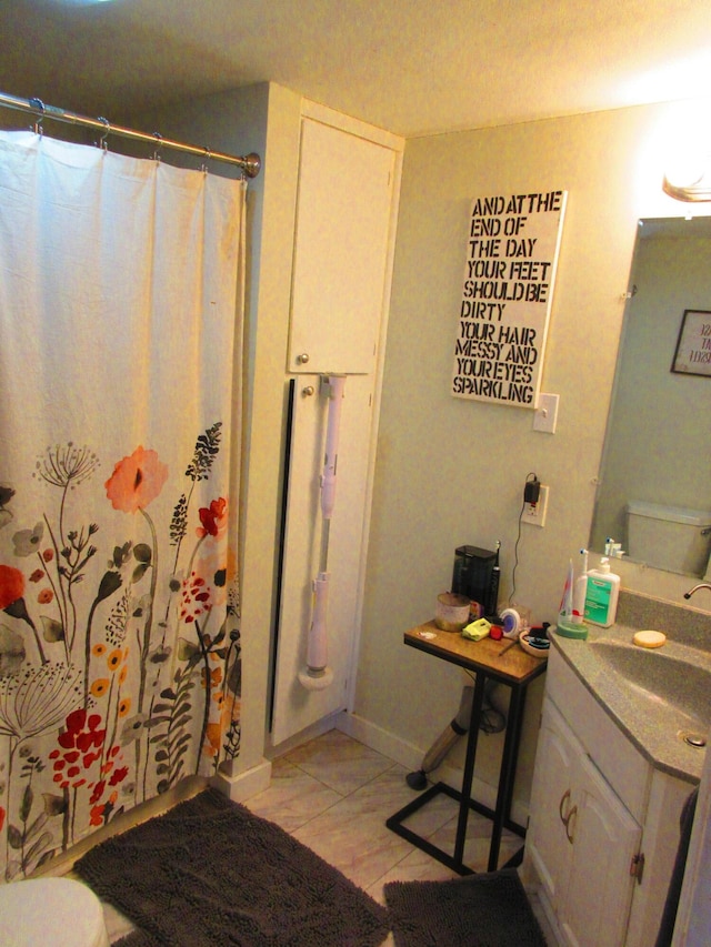 bathroom featuring vanity, a shower with shower curtain, and baseboards