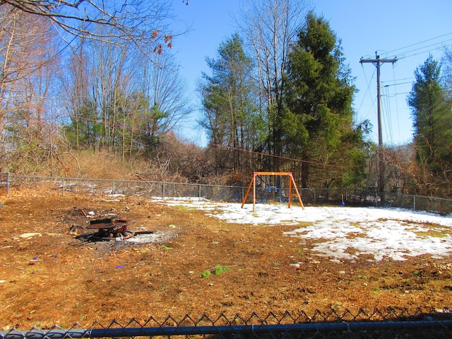 view of yard featuring playground community and fence