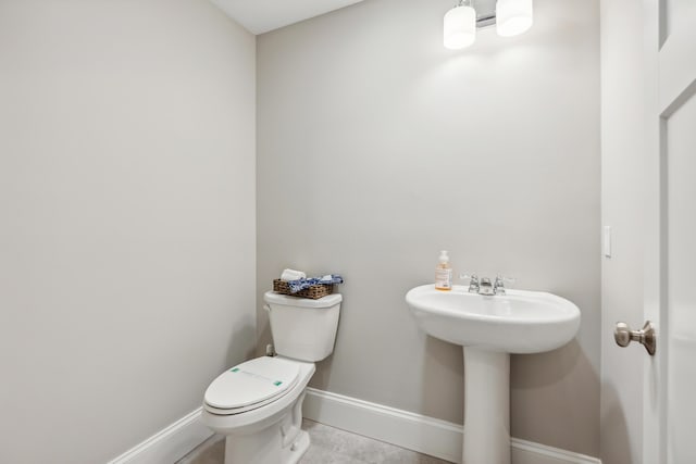 bathroom with tile patterned floors, toilet, and baseboards