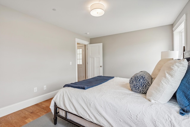 bedroom with baseboards and wood finished floors