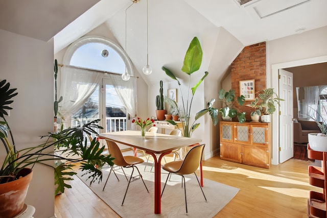 dining room featuring visible vents, lofted ceiling, and light wood finished floors