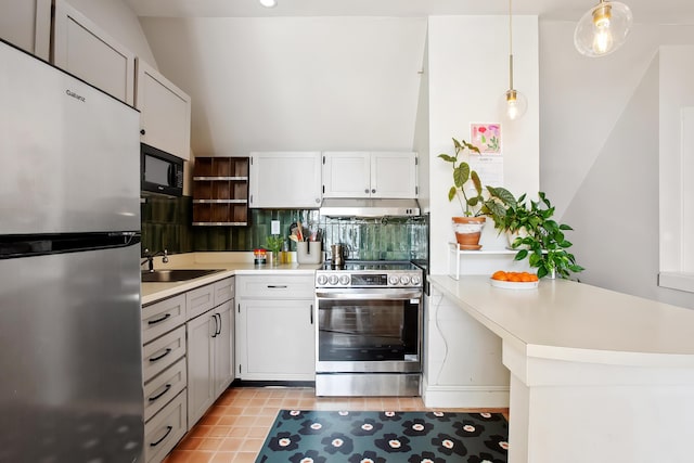 kitchen with under cabinet range hood, decorative light fixtures, tasteful backsplash, stainless steel appliances, and light countertops