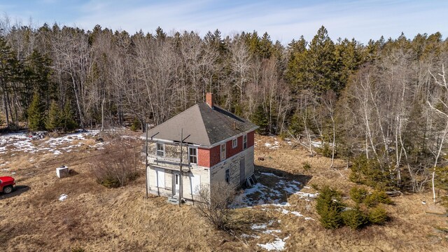 birds eye view of property featuring a forest view