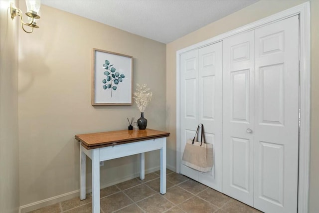 interior space featuring baseboards and a textured ceiling