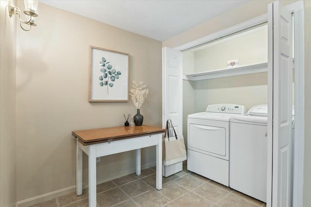 washroom featuring washing machine and clothes dryer, laundry area, baseboards, and light tile patterned floors