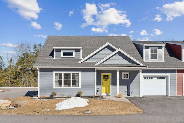 view of front of house featuring an attached garage, driveway, and a shingled roof