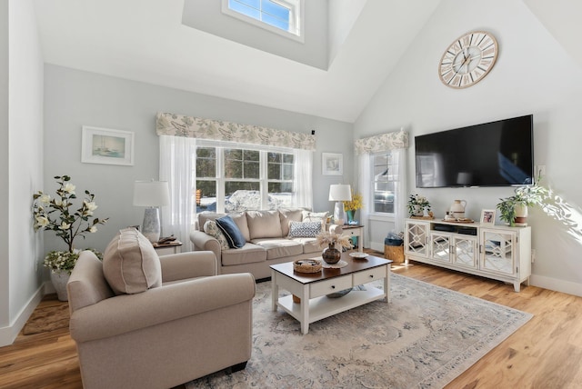 living room featuring high vaulted ceiling, baseboards, and wood finished floors