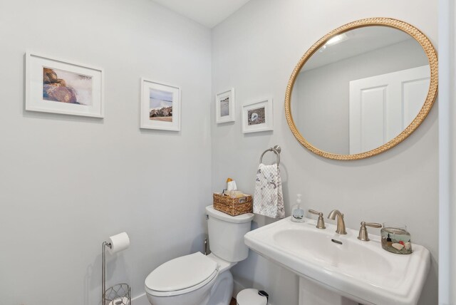 half bathroom featuring toilet and a sink