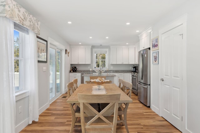 dining area featuring recessed lighting, light wood-type flooring, and baseboards