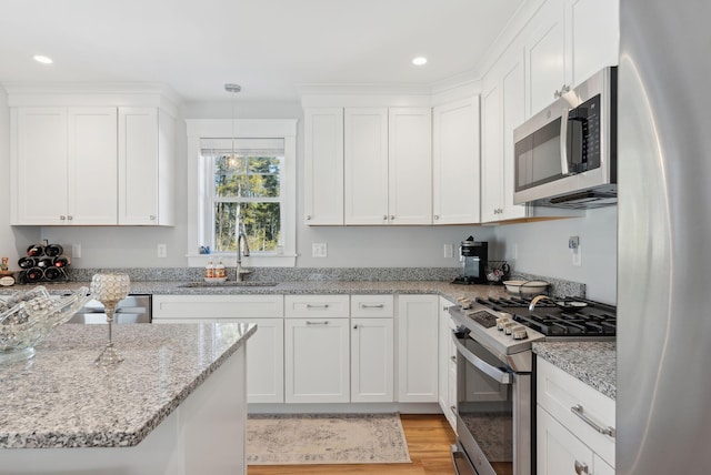 kitchen with light wood-type flooring, a sink, recessed lighting, stainless steel appliances, and white cabinets