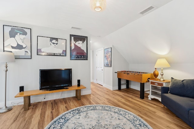 living room featuring visible vents, lofted ceiling, and wood finished floors