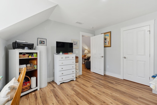 interior space with lofted ceiling, light wood-style flooring, and visible vents