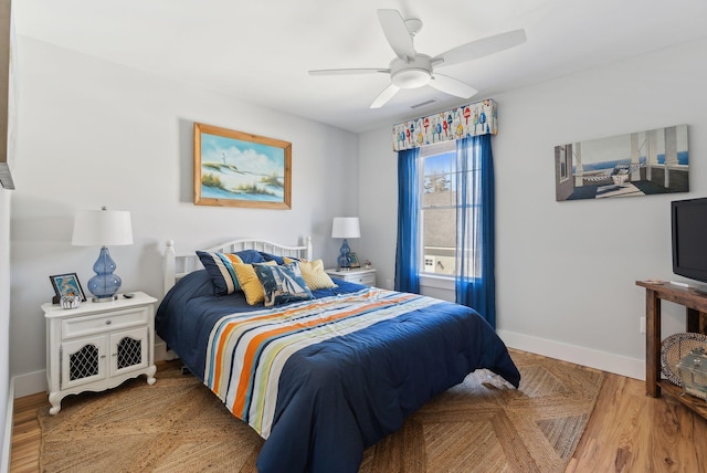 bedroom featuring visible vents, ceiling fan, baseboards, and light wood-style floors