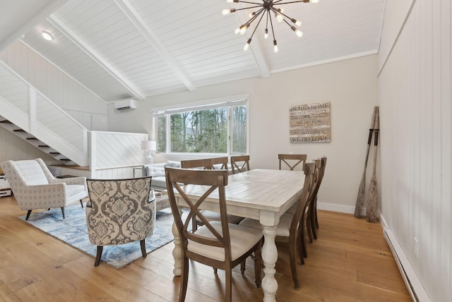 dining area with light wood finished floors, lofted ceiling with beams, a wall mounted AC, and a baseboard radiator