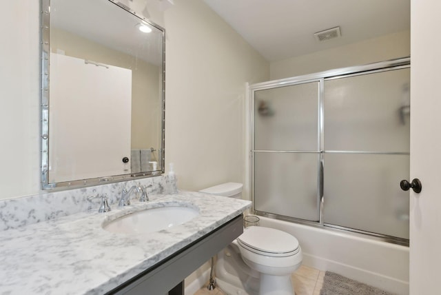 full bathroom featuring tile patterned floors, visible vents, toilet, shower / bath combination with glass door, and vanity