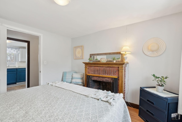 35 Grove Ave, Old Orchard Beach, ME 04064 - bedroom featuring ensuite bath, light wood-style flooring, and a fireplace