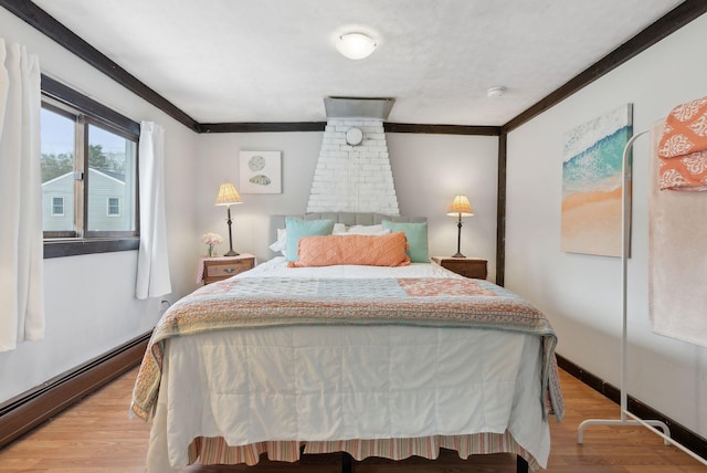 35 Grove Ave, Old Orchard Beach, ME 04064 - bedroom featuring light wood-type flooring, a baseboard radiator, baseboards, and crown molding