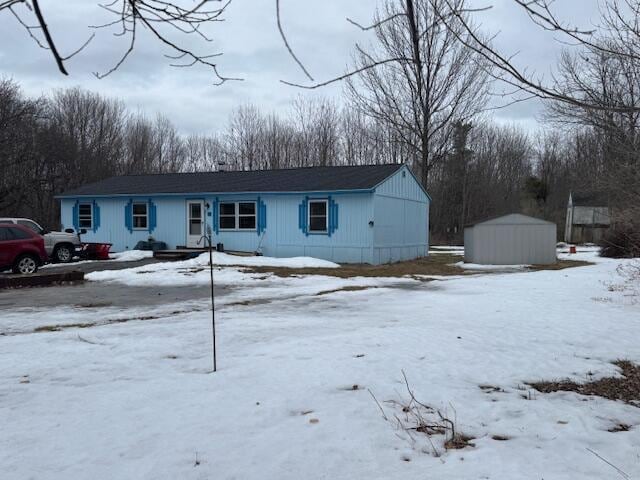 view of front of property featuring an outbuilding and a shed