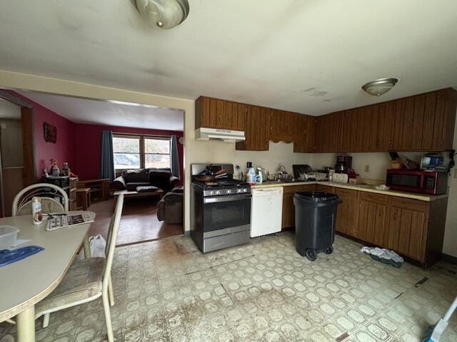 kitchen featuring brown cabinetry, light floors, light countertops, under cabinet range hood, and appliances with stainless steel finishes